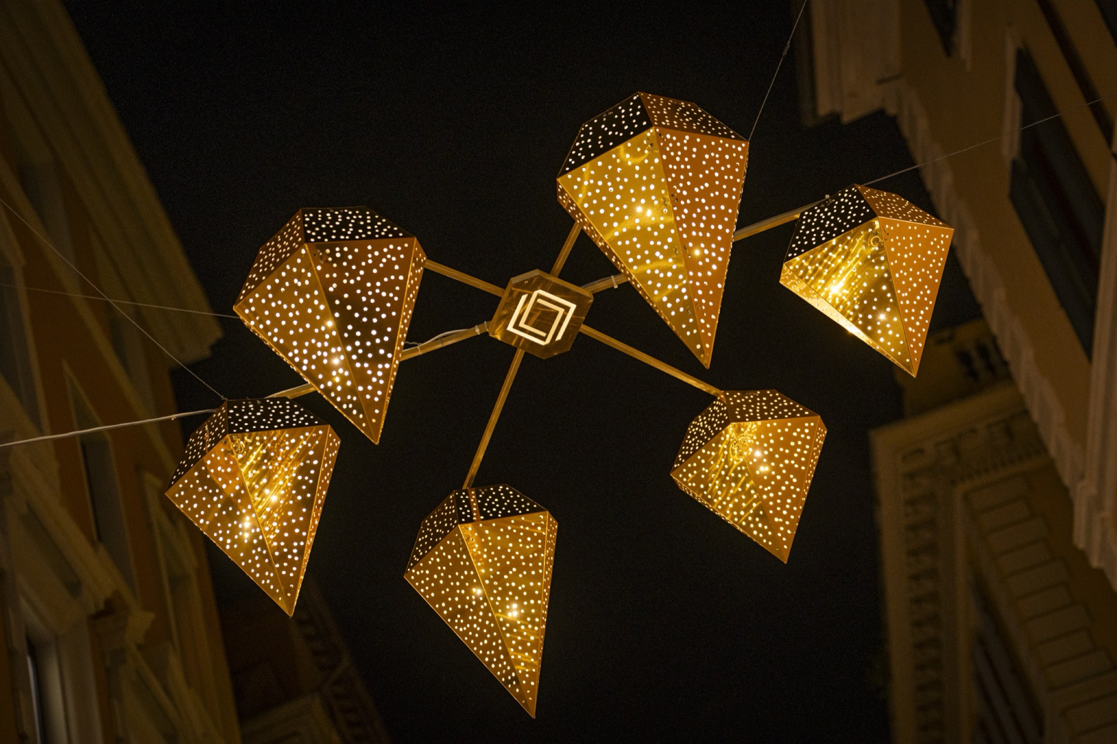 Suspended light installation with golden lanterns
